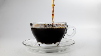 dark Coffee poring dripping splash shadow liquid swirl in glass cup saucer on white background stop motion