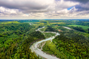 Fototapeta na wymiar Aerial view at the curvy Isar river at a sunny but cloudy day from nearly 100m from above in southern bavaria, germany. Beautiful nature at springtime.
