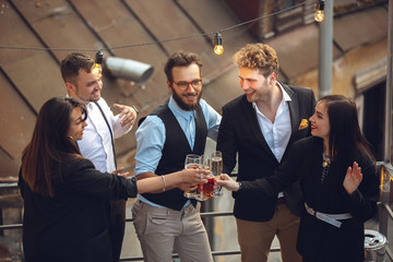 Cheers. Young people celebrating, look happy, have party at office or bar. Men and women drinking...