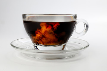 dark Coffee poring white milk dripping splash shadow liquid swirl in glass cup saucer on white background