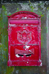 old, english red mailbox on an old wal 