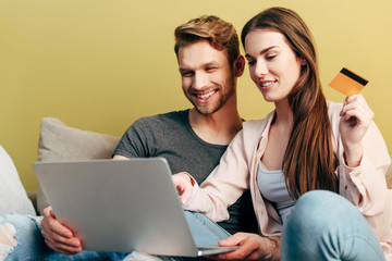 happy man online shopping near girl with credit card and laptop