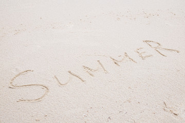 Concept: SUMMER word on white clean sand.