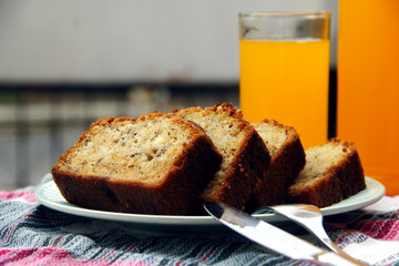Sliced banana bread loaf and orange juice drink