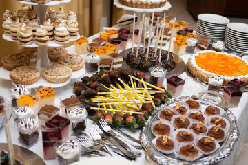 
Sweet chocolate cream cakes and fresh fruits on sweet table at wedding and events