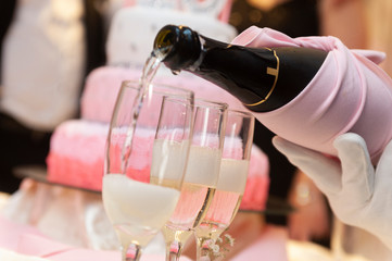 filling champagne glasses served by hand with white gloves to toast