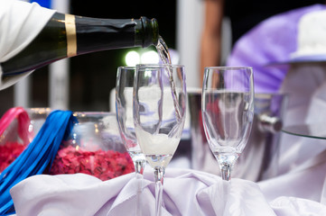 filling champagne glasses served by hand with white gloves to toast