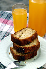 Sliced banana bread loaf and orange juice drink