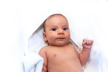 Adorable 2 months old little baby boy on towel after bath over white background