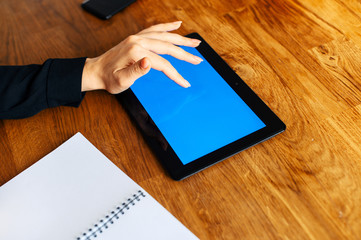 Back view close-up female finger touches of blank tablet screen. Copy space for text. Technology and digitalization concept