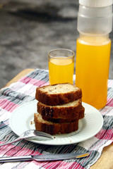 Sliced banana bread loaf and orange juice drink