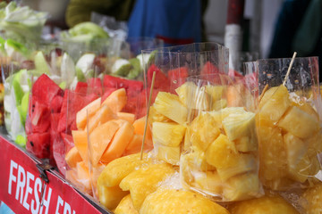 Plastic bags with fruit, such as grapefruit, watermelon, mango at a street stall