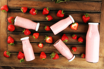 Glass of fresh strawberry shake, smoothie or milkshake and fresh strawberries on table. Healthy...
