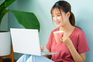 Asian woman sitting on the floor while she working from home