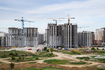 construction of multi-storey residential buildings. Tower cranes at a construction site.