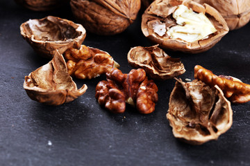 Walnut kernels and group of whole walnuts on rustic old table