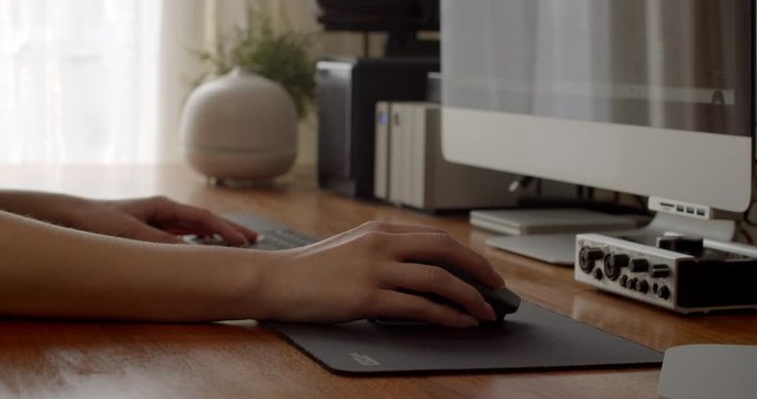 Close up of female's hand navigating computer program with mouse in her home office