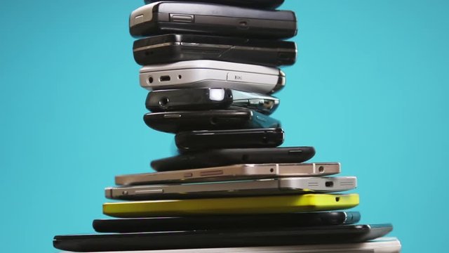 outdated and modern models of smartphones and mobile phones. dirty, broken and old smartphones on a blue background. Rotation