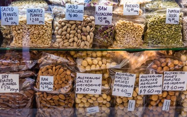Many bags of various types of nuts for sale in a glass counter at the Queen Victoria Market in...