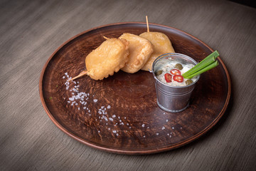 Baked cheese on studs with sauce. restaurant giving. for the menu of cafe. wooden table