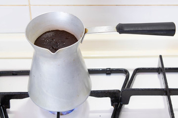 Brewing coffee in a turk on the stove