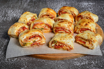 Mini pizza rolls on wooden board