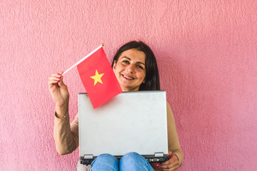 woman with laptop computer and flag of Vietnam