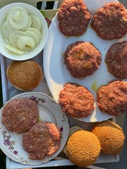cooking a homemade burger outdoors. raw burger ingredients top view, outdoors homemade process of cooking on the yard during quarantine. Top view