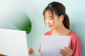 Asian woman sitting on the floor while she working from home