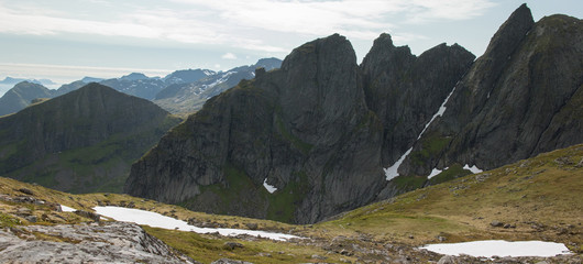 Fototapeta na wymiar Hikers make their way towards the mountain peak in Lofoten.