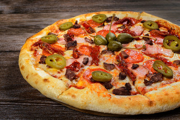 Pizza with jalapeno pepper, capers, bacon and pepperoni