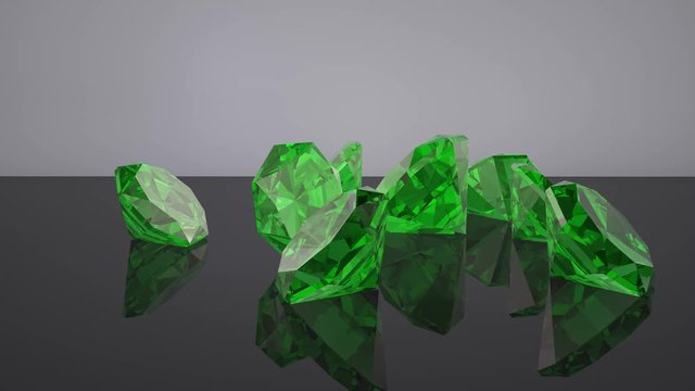 Green emerald diamonds fall on a black glossy. surface. 3D animation