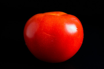 red tomato on a black background