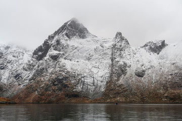 A sea kayaker pauses for a moment to take in the magnitude of his surroundings ( Lofoten - Norway )
