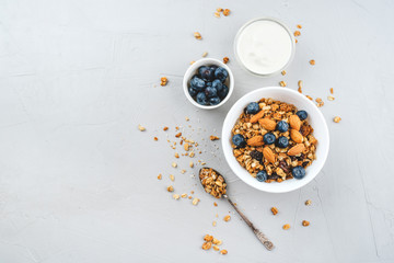 Baked granola with yogurt and blueberries on a gray table. Top view.