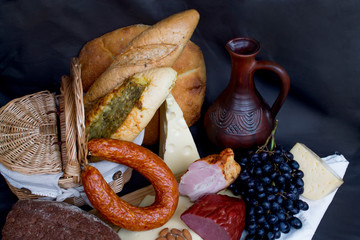 Still-life. Wine. Glass of wine. Cheese. Sausage. Bread. Basket. Grape. A decanter of wine. Nuts...