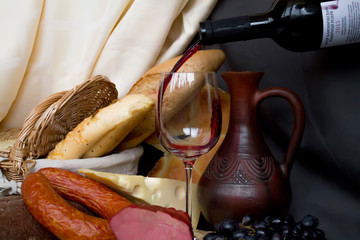 Still-life. Wine. Glass of wine. Cheese. Sausage. Bread. Basket. Grape. A decanter of wine. Nuts almonds