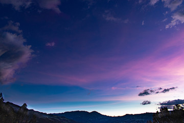 Cielo azul oscuro con nubes lilas, fucsias