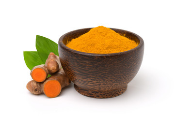 Turmeric (curcumin) powder in a black wooden bowl,root and leaves isolated on a white...