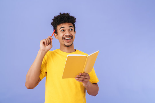 Photo of african american man smiling and making notes in planner