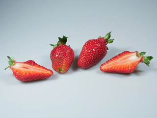 a pair of fresh berries and one cut strawberries lie on the table