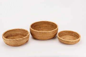 Three woven bamboo baskets against a white background.