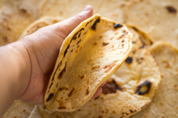 Pão Pita, Pão Sírio de trigo sobre a mesa com fotografia ao topo - Segurando com a mão