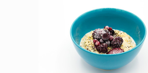 Oatmeal with blueberries and sugar in blue glass bowl isolated on white background. Cereals. Healthy breakfast. good digestion. Space for text.