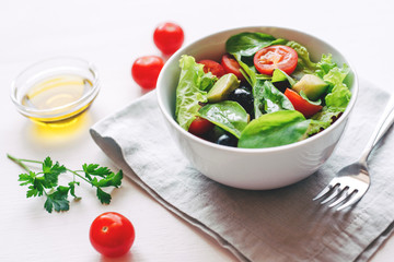 Fresh salad of avocado, cherry, arugula and olives made at home. Vegan food. The concept of healthy eating. Front view.