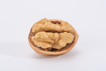 The walnuts poke open the shell to reveal the kernels in a white background