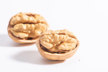 The walnuts poke open the shell to reveal the kernels in a white background