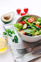Fresh salad of avocado, cherry, arugula and olives made at home. Vegan food. The concept of healthy eating. Front view.