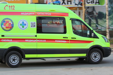 14-05-2020. Russia, Syktyvkar. White ambulance with a red stripe with blue flashing lights on a city street in Russia.