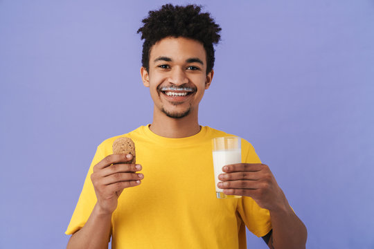 Photo Of African American Man Smiling While Eating Cookie With Milk